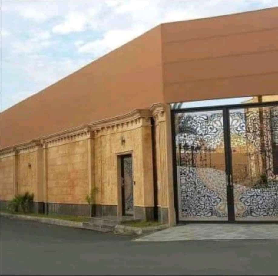 سور بكسوة حجرية وبوابة حديد مزخرفة